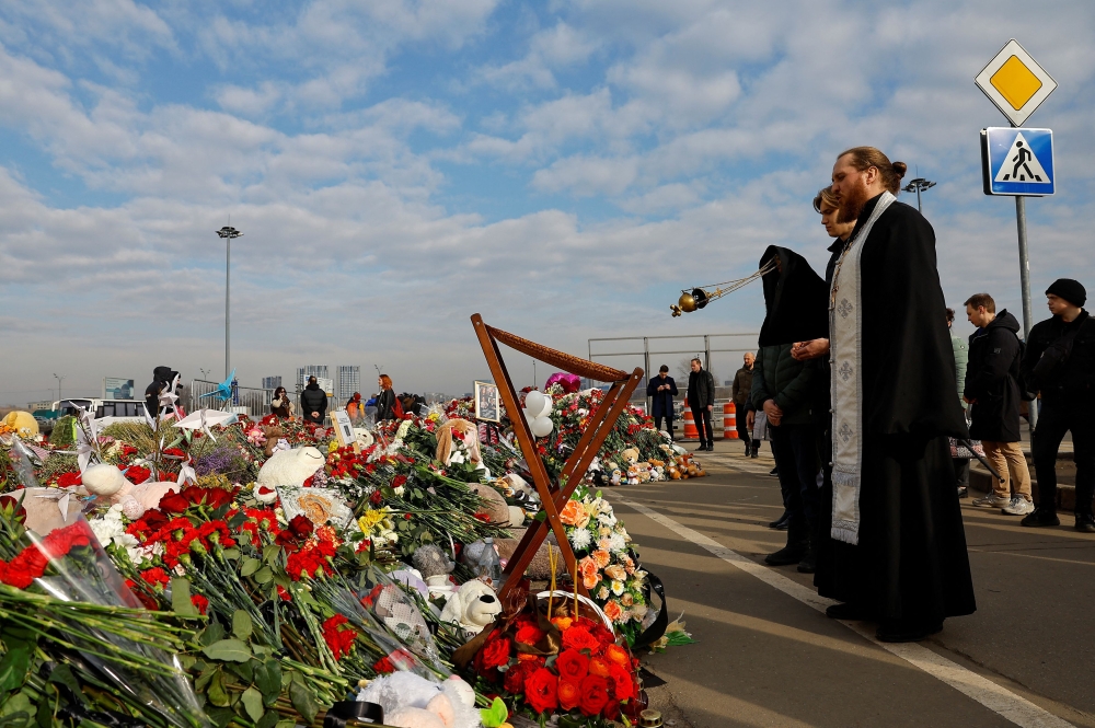 Clergymen conduct a memorial service for victims at a makeshift memorial near the Crocus City Hall following a deadly attack on the concert venue outside Moscow, Russia, March 29, 2024. — Reuters pic