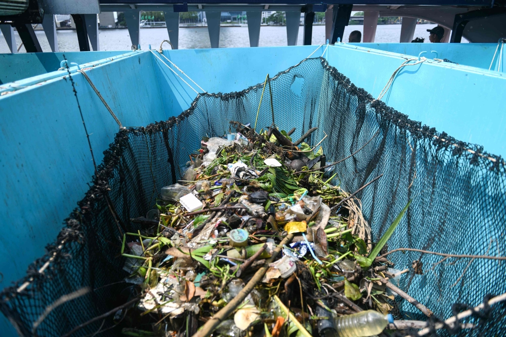Floating plastic, trash and plants are collected into containers onboard The Ocean Cleanup's Interceptor during a press visit on the Chao Phraya river in Bangkok on March 26, 2024. — AFP pic