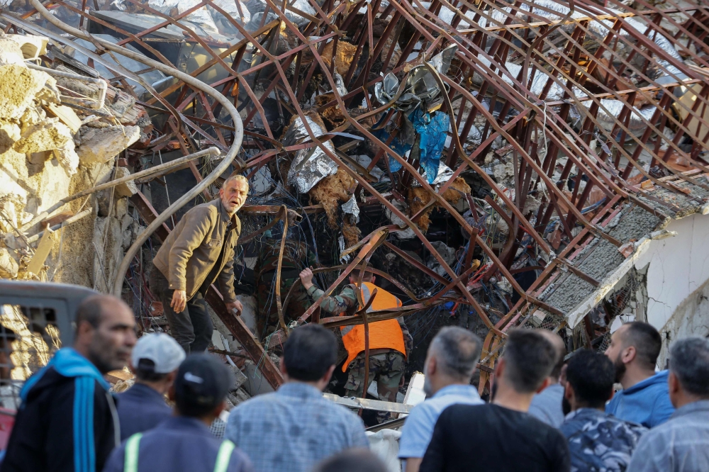 Emergency and security personnel inspect the rubble at the site of strikes which hit a building next to the Iranian embassy in Syria's capital Damascus, on April 1, 2024. — AFP pic