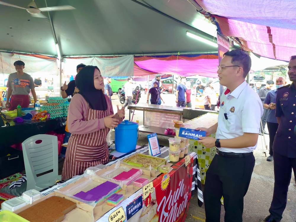 Johor Investment, Trade and Consumer Affairs Committee chairman Lee Ting Han (far right) with a trader during the Ramadan Bazaar Walkabout Programme in Taman Perling in Johor Baru April 1, 2024 — Picture by Ben Tan