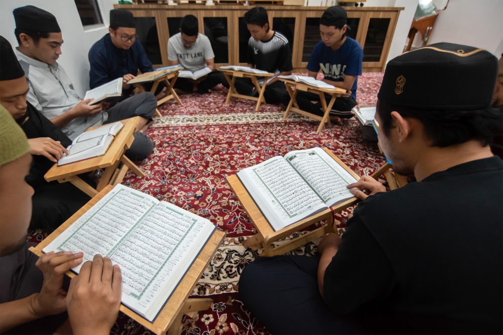 A group of men are seen reading the Quran. ― Bernama pic