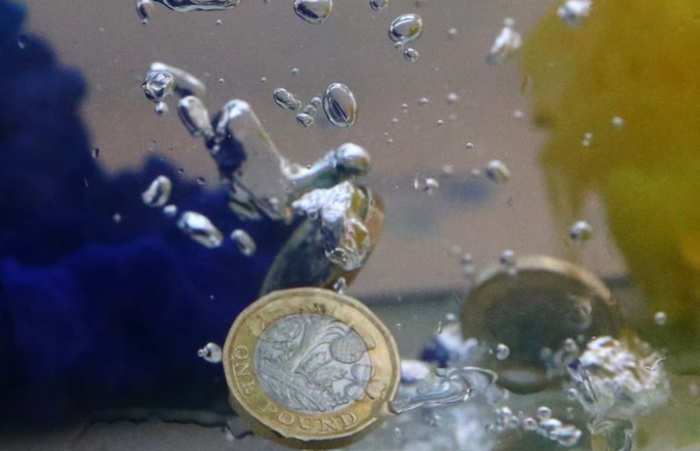 UK pound coins plunge into water coloured with the European Union flag colours in this illustration picture, October 26, 2017. — Reuters pic