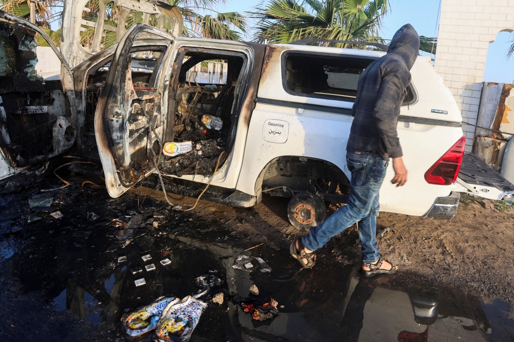A Palestinian inspects a vehicle where employees from the World Central Kitchen (WCK), including foreigners, were killed in an Israeli airstrike, according to the NGO as the Israeli military said it was conducting a thorough review at the highest levels to understand the circumstances of this ‘tragic’ incident, amid the ongoing conflict between Israel and Hamas, in Deir Al-Balah, in the central Gaza, Strip April 2, 2024. –– Reuters pic