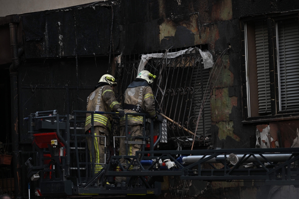 Firefighters at the site of the fire, which killed at least 29 people in a 16-storey residential building in Istanbul on April 2. — AFP pic