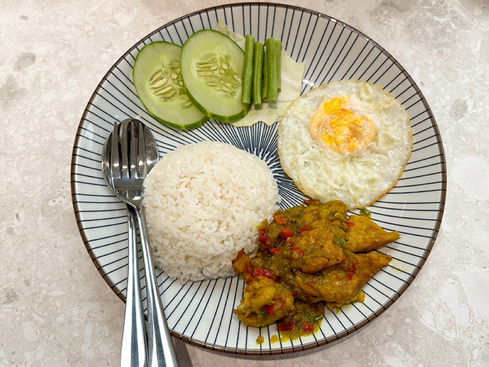 The menu is expanded to include rice dishes with a spicy Phad Kra Pow chicken, fried egg and vegetables
