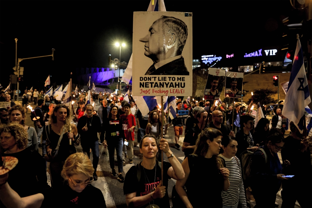 Anti-government protesters gather with signs and candles as they stage a four-day sit-in Jerusalem on April 2, 2024 calling for the dissolution of the Israeli government and the return of Israelis held hostage in Gaza. — AFP pic