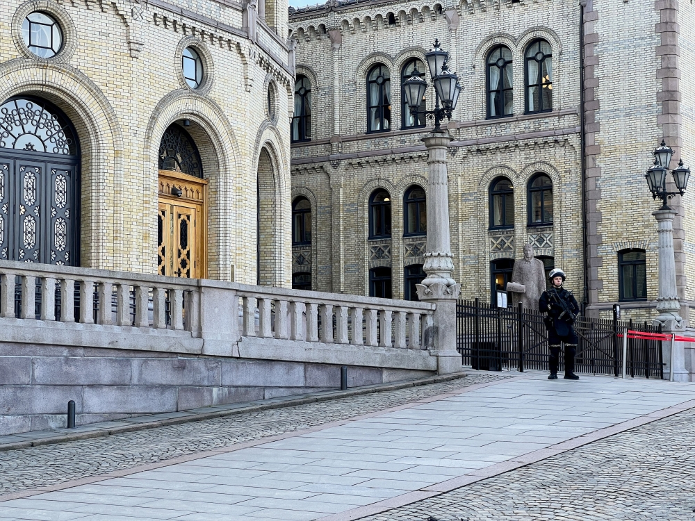 An armed police officer guards the main entrance to the Norwegian parliament after it received a bomb threat, in Oslo, Norway April 3, 2024. –– Reuters