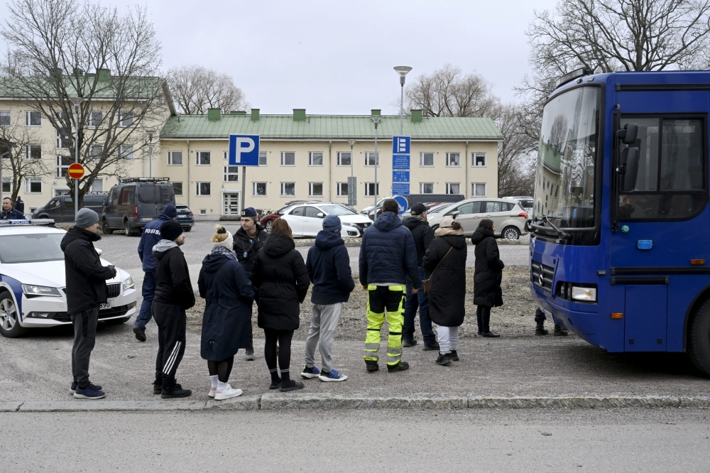 Police officers talk to family members of pupils at the Viertola comprehensive school in Vantaa, Finland, on April 2, 2024. — Lehtikuva via Reuters pic