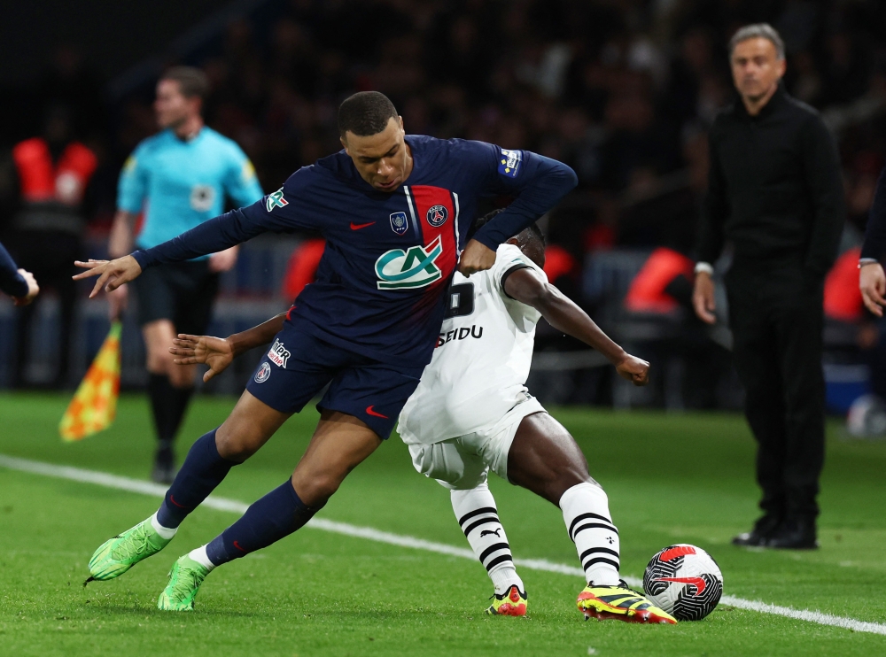 Paris St Germain's Kylian Mbappe in action with Stade Rennes' Alidu Seidu at the Parc des Princes in Paris April 3, 2024. — Reuters pic