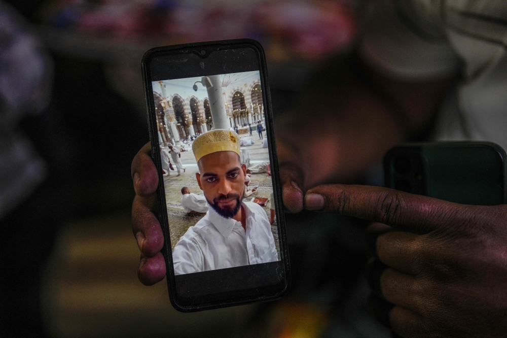 This photograph taken on March 18, 2024 shows Parvez Qureshi with a picture of his younger brother Faheem Qureshi, who was killed in anti-Muslim riots in February, at his house in Haldwani, in India's Uttarakhand state. — AFP pic
