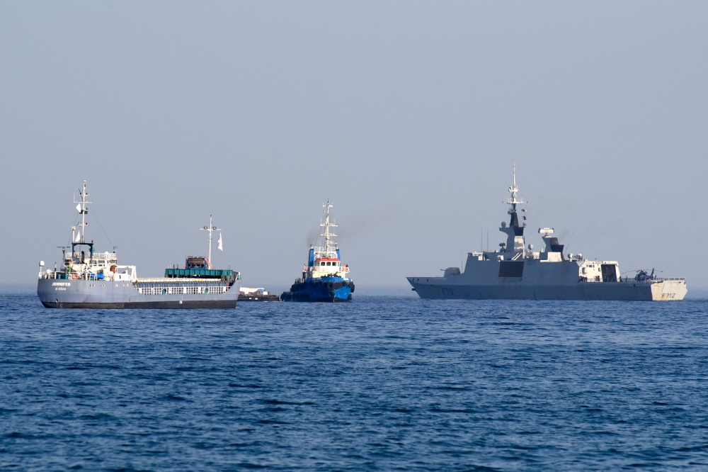 The barge Jenifer, part of a three ship flotilla carrying food aid for the Gaza Strip, sails next to the French frigate Courbet. — AFP pic