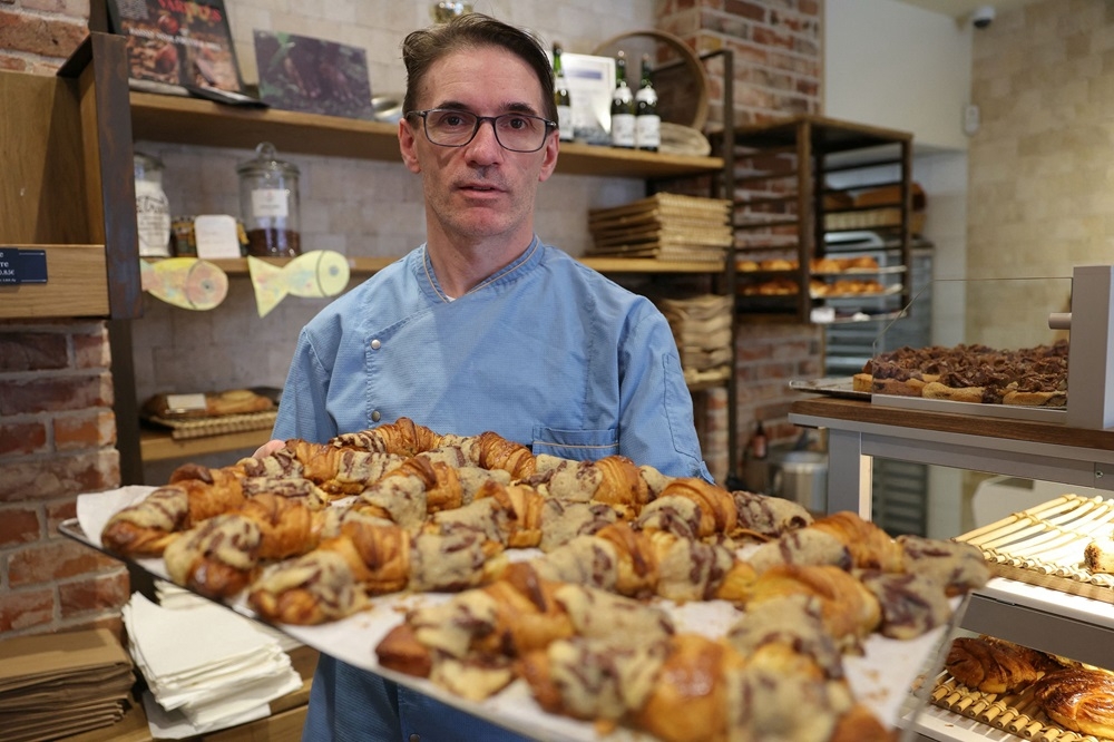 French pastry chef Stephane Louvard poses with his ‘Crookies’, a traditional French croissant mixed with cookie dough, in his pastry shop in Paris, on April 2, 2024. ― AFP pic