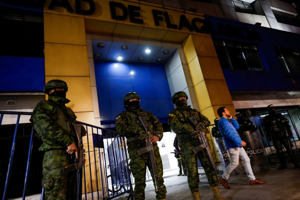 Police and military officials stand guard outside the Flagrancy Unit, where former Ecuador Vice President Jorge Glas is believed to be detained, in Quito April 6, 2024. — Reuters pic