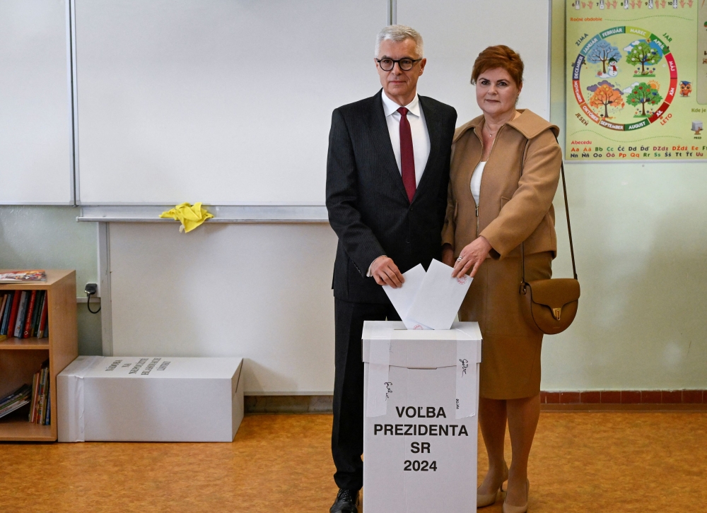 Slovakia's presidential candidate Ivan Korcok is joined by his wife Sona Korcokova as he casts his ballot during the country's presidential election run-off at a polling station in Senec, Slovakia, April 6, 2024. — Reuters pic  