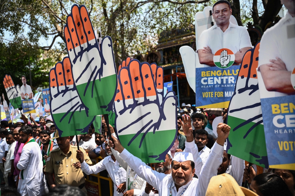File photo of Congress party supporters holding the party’s symbol and placards during a roadshow for Mansoor Ali Khan, election candidate for Bengaluru central, in Bengaluru on April 3, 2024, prior to filing his nomination papers for India’s upcoming general election. — AFP pic