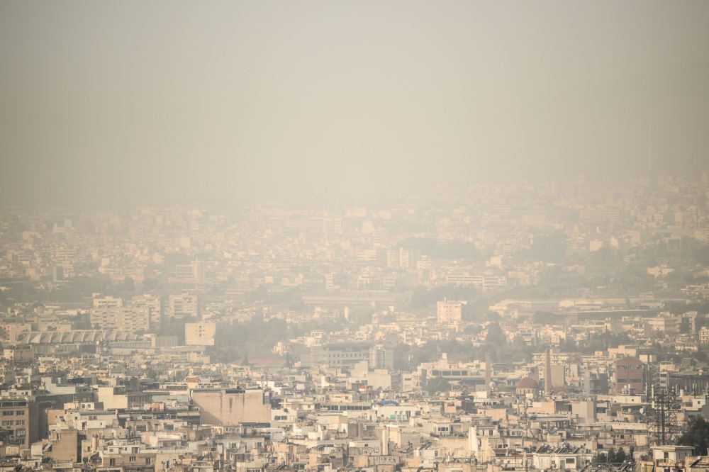 This file photo shows the city of Athens shrouded in haze, as persistent southerly winds carried waves of dust from the African continent across Greece, on April 2, 2024. — AFP pic