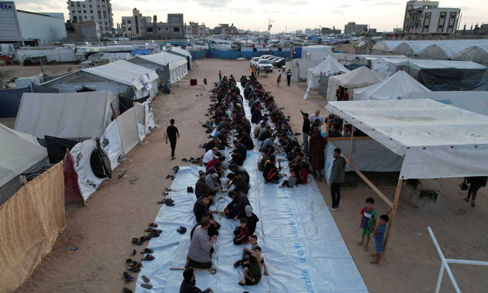 A drone view shows Palestinians, who were displaced by Israel's military offensive, gathering to have their Iftar (breaking of the fast) during the holy month of Ramadan, in Rafah in the southern Gaza Strip April 6, 2024. — Reuters pic