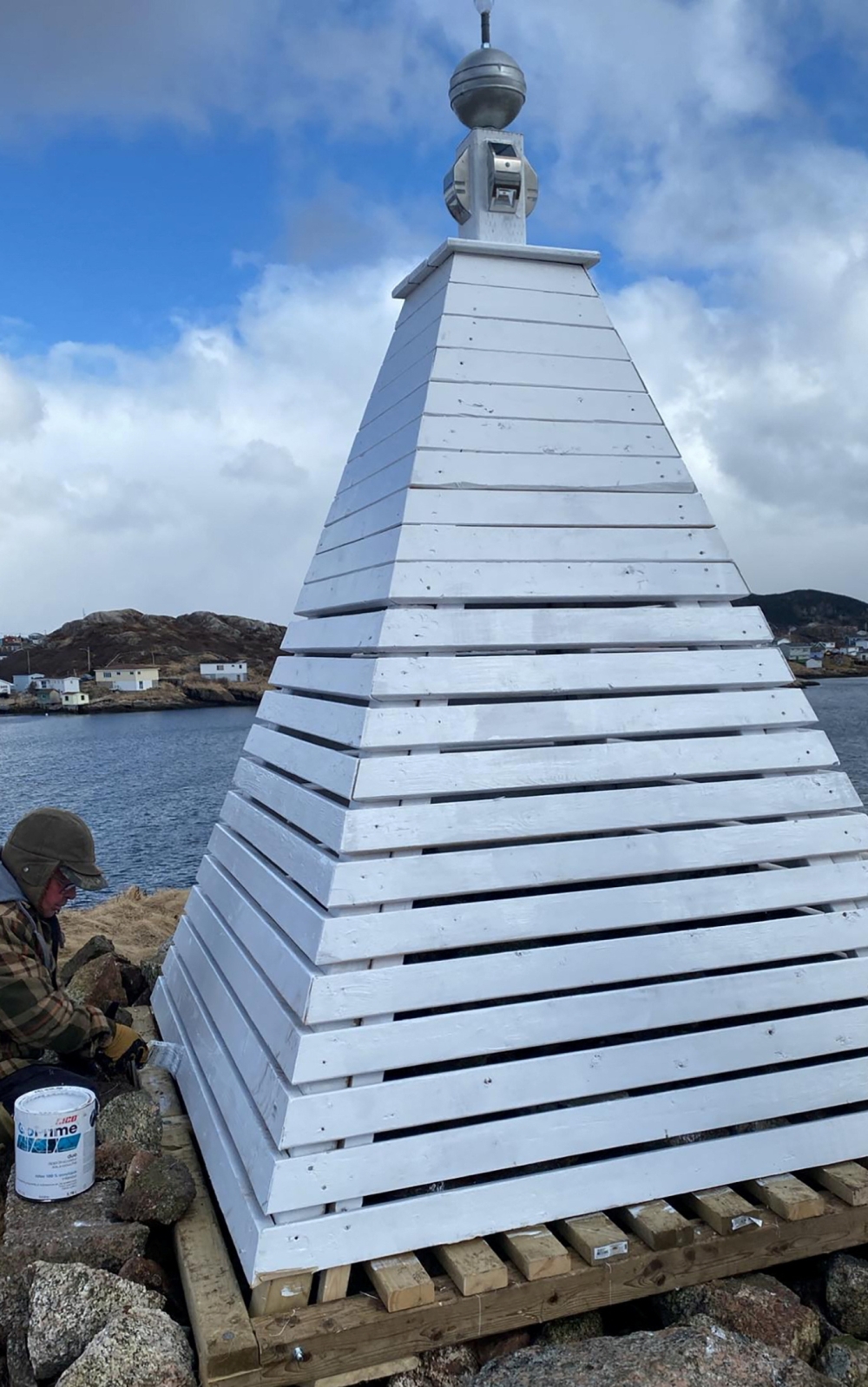 A person paints a beacon on Eclipse Island, named by Royal Navy explorer Captain James Cook in 1766, just off the town of Burgeo, Newfoundland, Canada in an undated photograph. — Michael Ward handout pic via Reuters 
