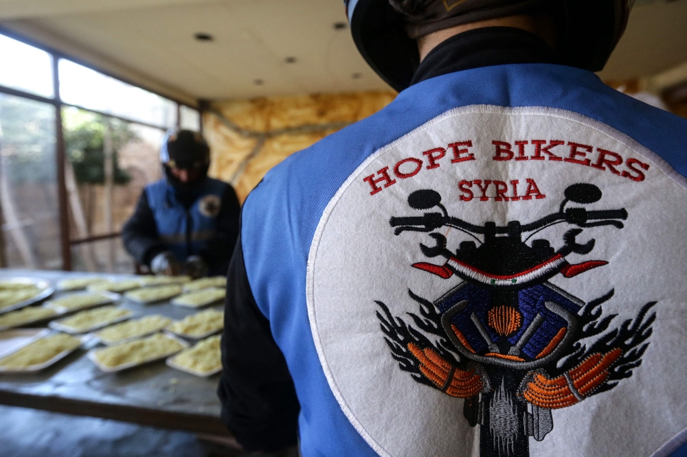 Members of motorcycle club Hope Bikers Syria help prepare distribute 