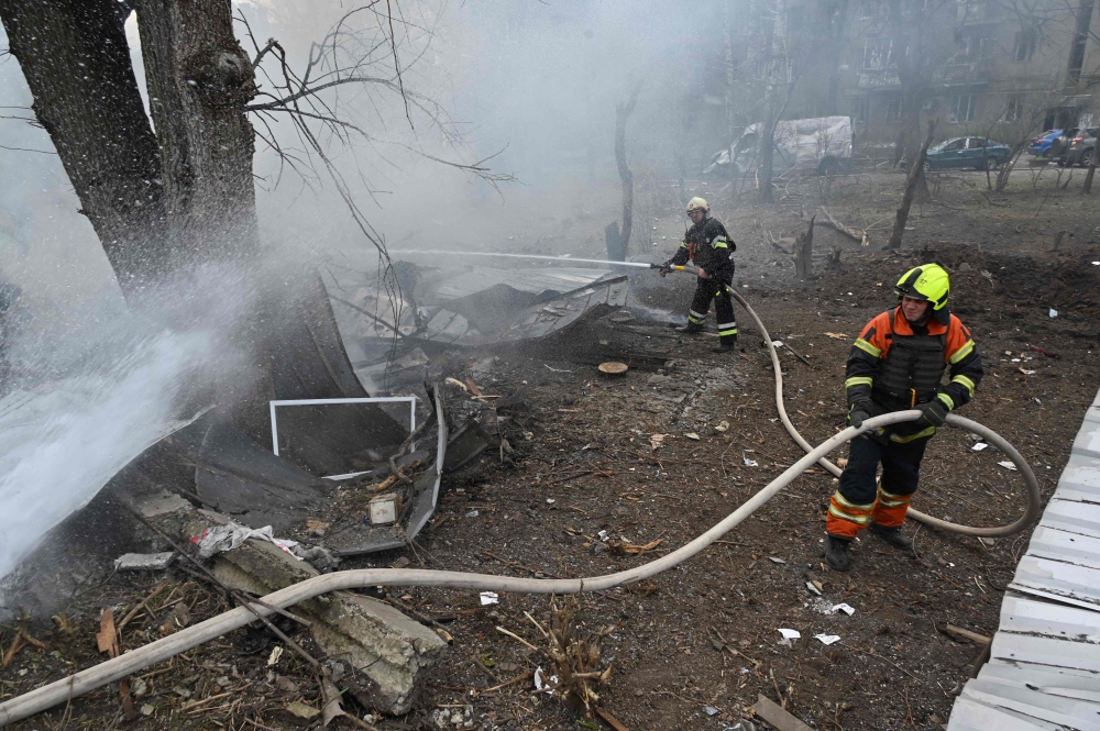 Firefighters extinguish a fire at the site of a missile strike in the center of Kharkiv, on April 7, 2024, amid the Russian invasion in Ukraine. — AFP pic