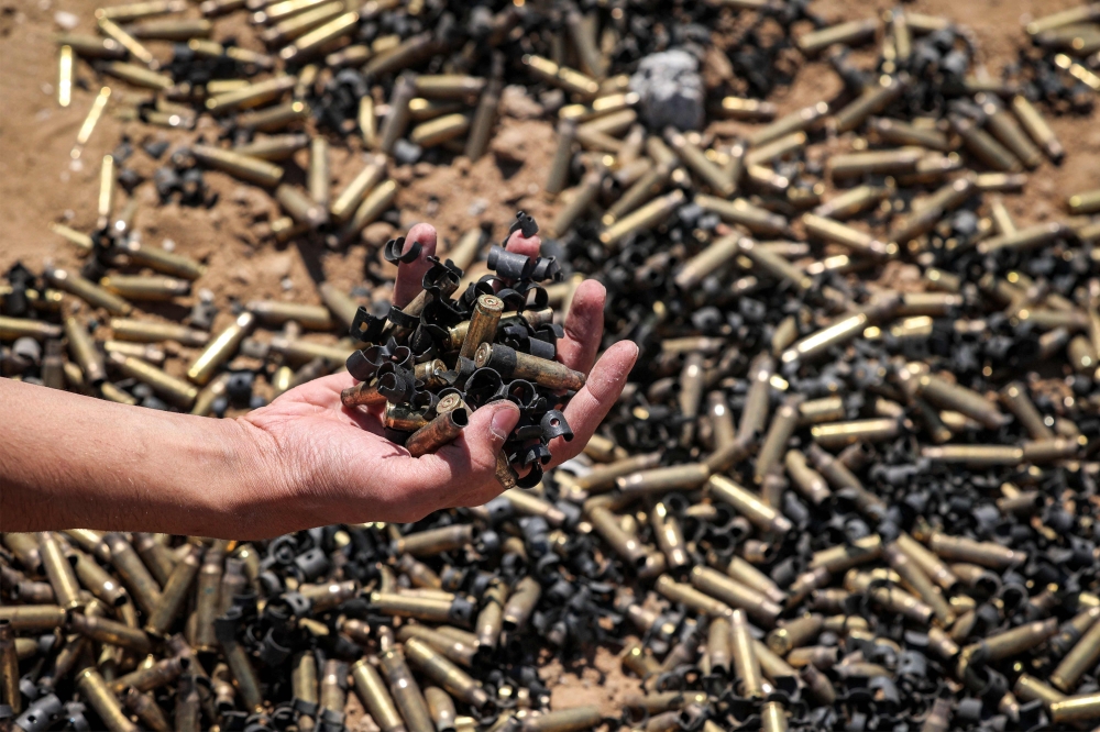 A person holds a handful of spent bullet casings in Khan Yunis on April 7, 2024 after Israel pulled its ground forces out of the southern Gaza Strip. — AFP pic