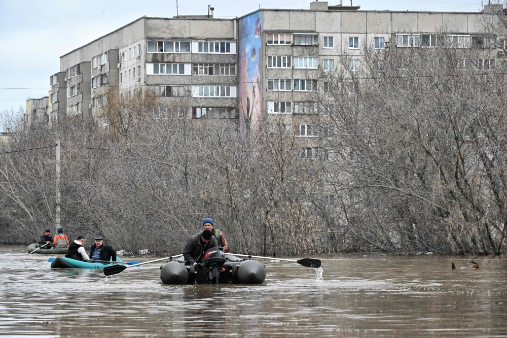 This picture taken on April 8, 2024 shows rescuers evacuating residents from the flooded part of the city of Orsk. — AFP pic