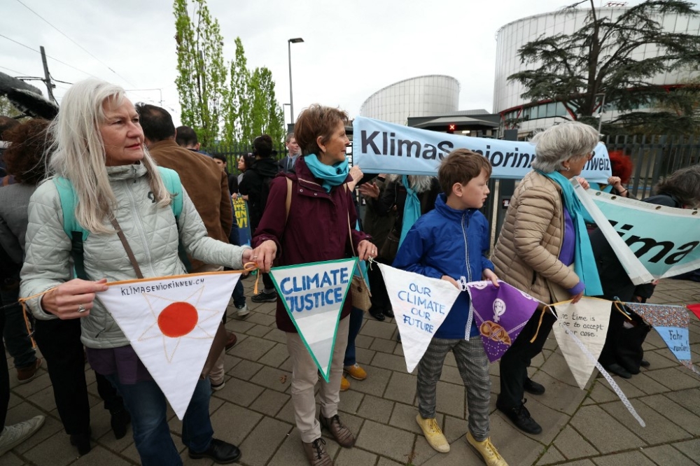 Protesters hold pennants during a rally before the European Court of Human Rights (ECHR) decides in three separate cases if states are doing enough in the face of global warming in rulings that could force them to do more, in Strasbourg, eastern France, on April 9, 2024. — AFP pic