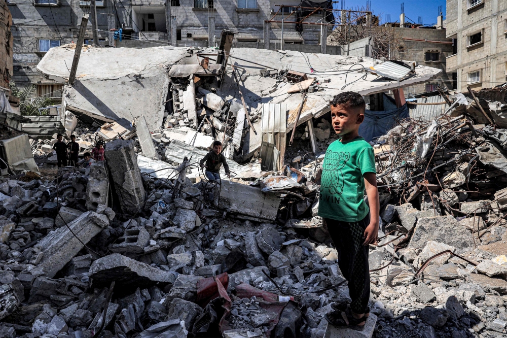 A boy stands by the rubble of a collapsed building in Rafah in the southern Gaza Strip April 9, 2024 amid the ongoing conflict in the Palestinian territory between Israel and Hamas. — AFP pic