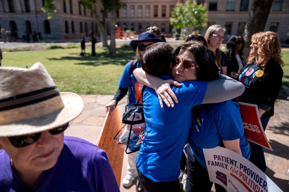 Abortion rights activists Marion Weich and Carolyn LaMantia embrace during a news conference addressing the Arizona Supreme Court's ruling to uphold a 160-year-old near-total abortion ban at the Arizona state Capitol in Phoenix, Arizona April 9, 2024. — Picture by Joel Angel Juarez/USA Today Network via Reuters