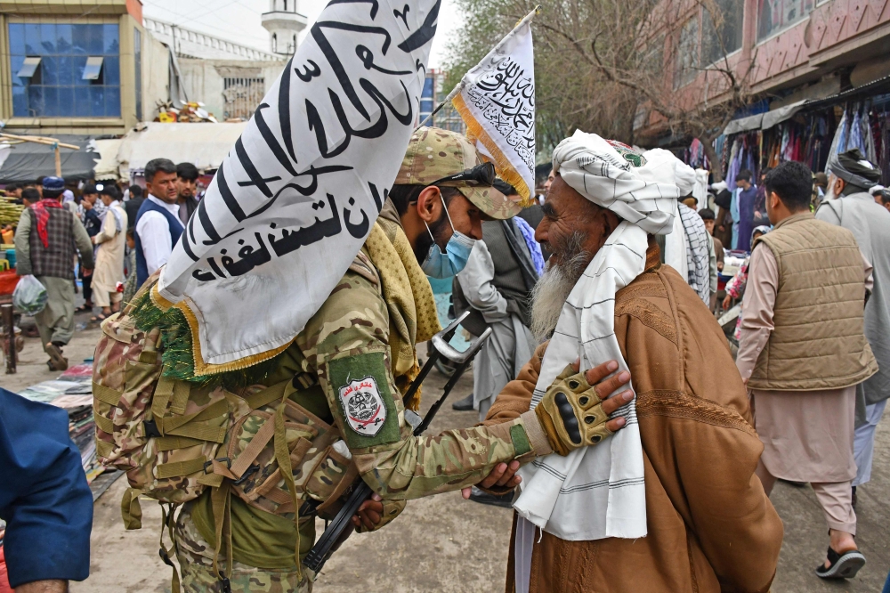 A Taliban security personnel greets a Muslim devotee after Eid al-Fitr prayers at a mosque in Pul-e-Khumri city of Baghlan province on April 10, 2024. — AFP pic