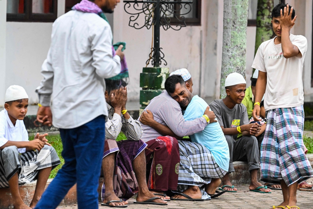 Rohingya refugees embrace each other after taking part in Eid al-Fitr prayers, marking the end of the holy month of Ramadan, at a temporary shelter in Meulaboh, Indonesia's Aceh province April 10, 2024. — AFP pic