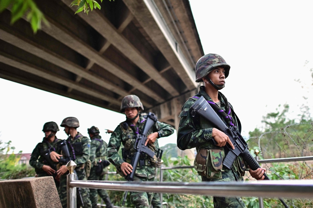 Thai military personnel stand guard overlooking the Moei river on the Thai side, near the Tak border checkpoint with Myanmar, in Thailand's Mae Sot district April 10, 2024. — AFP pic