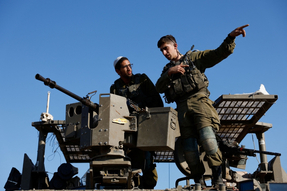 Israeli soldiers prepare near the Israel-Gaza border. — Reuters pic