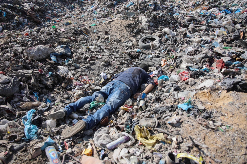 This picture shows a casualty on the ground following Israeli bombing of the Firas market area in Gaza City. — AFP pic