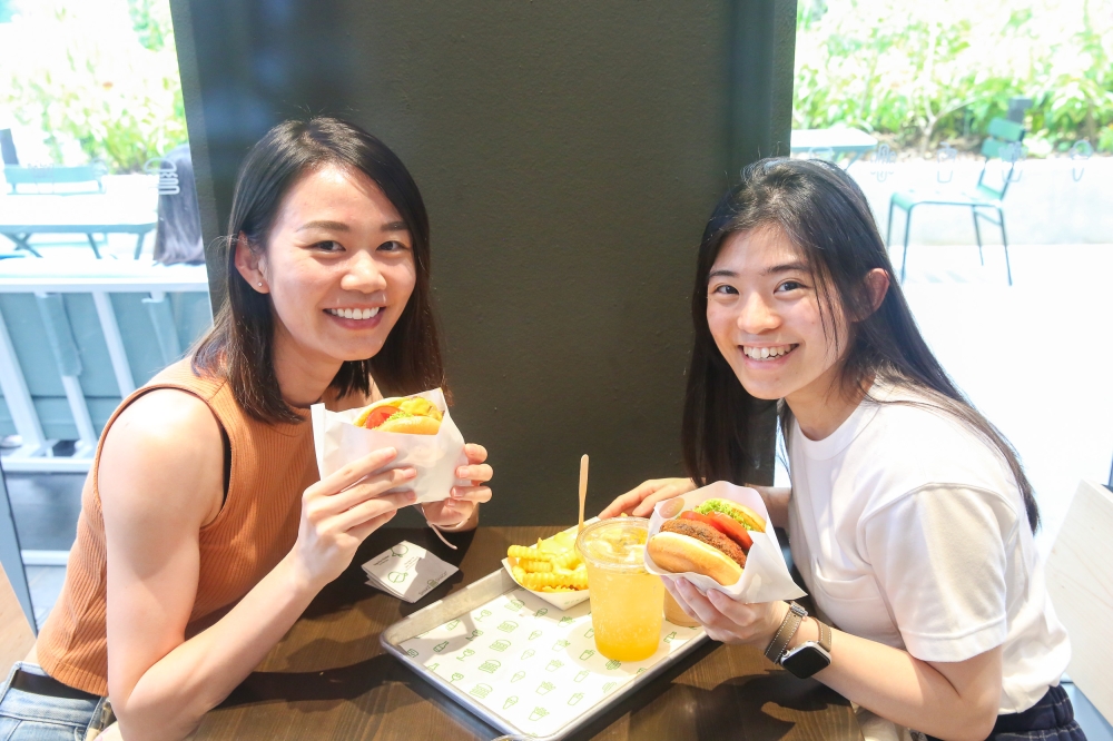 Carmen Phang 和 Sarah Teh 等了一个小时才拿到他们最喜欢的汉堡。  — 图片由 Choo Choy May 拍摄
