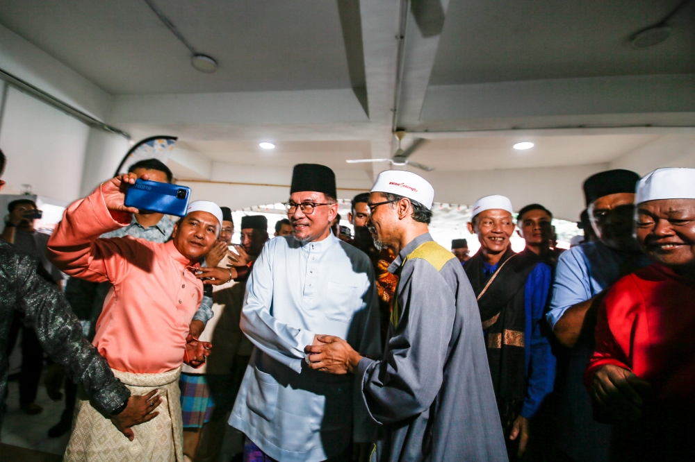 Prime Minister Datuk Seri Anwar Ibrahim (centre) shakes hands with members of the public at the Bandar Utama Batang Kali Mosque for the Hari Raya open house and Friday prayers in Batang Kali, Hulu Selangor April 12, 2024. — Picture by Hari Anggara