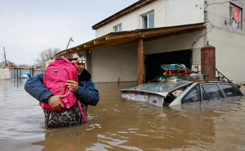 A local resident carries a backpack with his cats out of his flooded house in Orenburg, Russia April 12, 2024. — Reuters pic