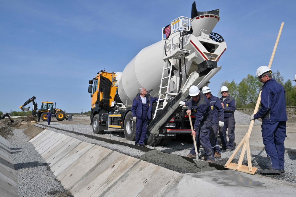 Workers pour concrete during preparatory activities before the construction of power units 5, 6 using the American Westinghouse technology at the Khmelnytsky Nuclear Power Plant (KhNPP) near Ukrainian city of Khmelnytsky on April 11, 2024. — AFP pic