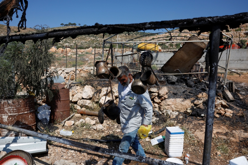 A Palestinian man inspects the damage to a house after Israeli settlers attack the village of al-Mughayyer, in the Israeli-occupied West Bank, April 13, 2024. — Reuters pic