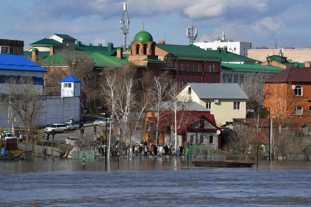 Residents stand on the edge of a flooded area in the city of Orenburg on April 13, 2024. Russian emergency services on April 13, 2024 said they had evacuated thousands of people from the Orenburg region in the south of the Urals as flood water continued to rise. — AFP pic