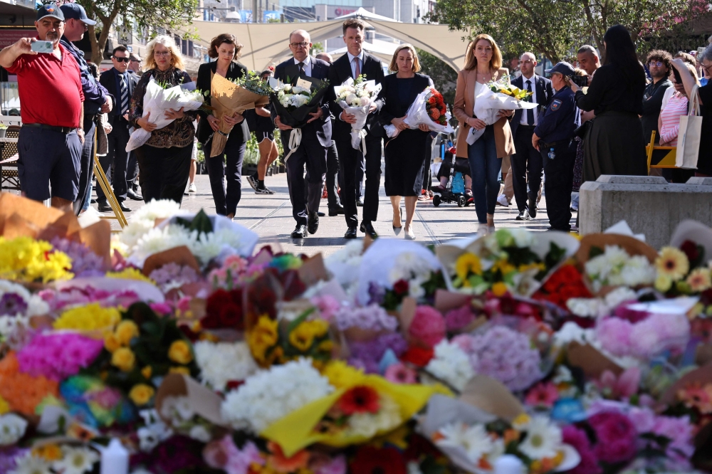 Australian Prime Minister Anthony Albanese (centre) with New South Wales Premier Chris Minns  outside the Westfield Bondi Junction shopping mall in Sydney on April 14, 2024. — AFP pic