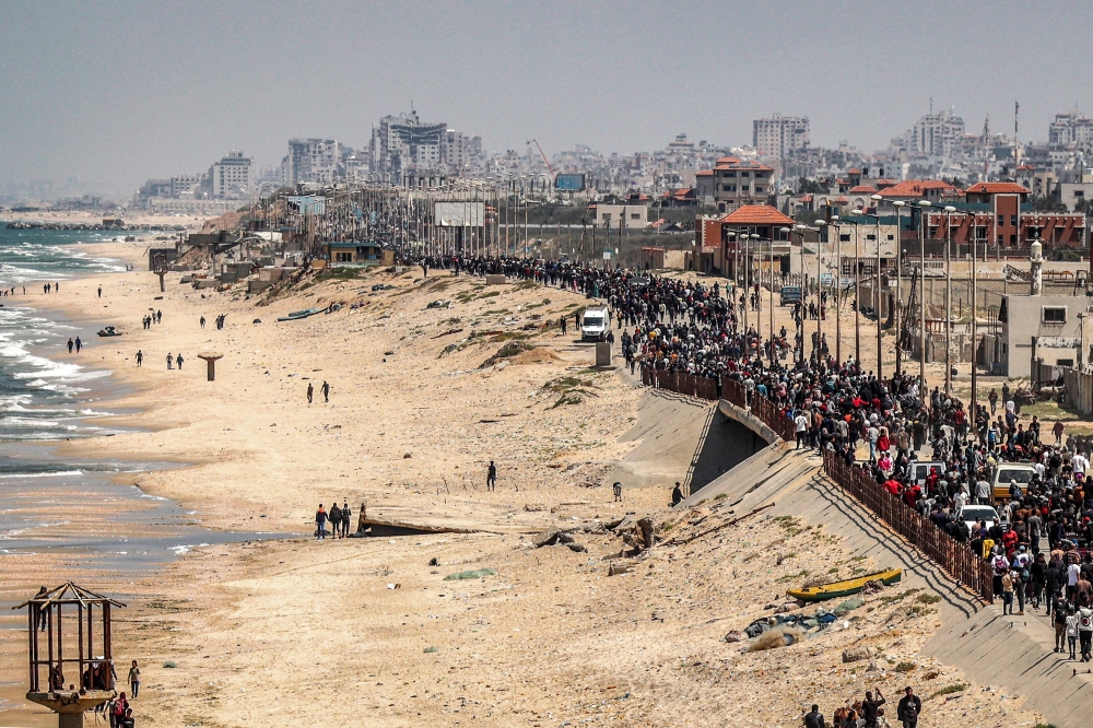 Displaced Palestinians take the coastal Rashid road to return to Gaza City as they pass through Nuseirat in the central Gaza Strip. — AFP pic