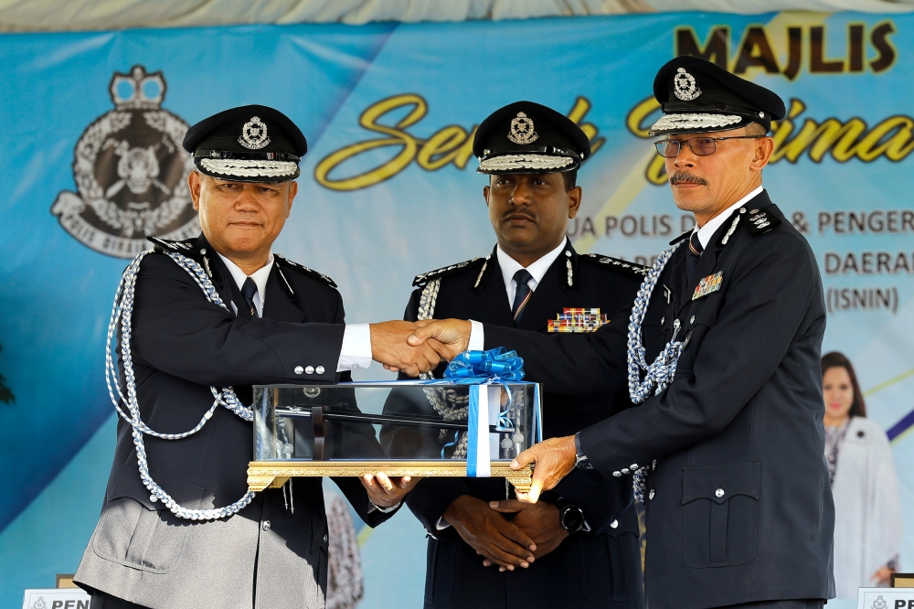 Selangor police chief Datuk Hussein Omar Khan (centre) witnesses the handover ceremony for the new KLIA police chief from Assistant Commissioner Imran Abd Rahman (left) to Assistant Commissioner Azman Shari’at (right) in Sepang April 15, 2024. — Bernama pic