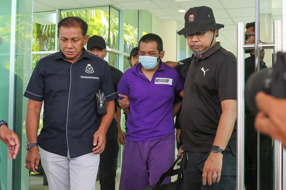 KLIA shooting suspect Hafizul Harawi (centre) is lead in handcuffs as he arrives at the Pangkalan Pasukan Gerakan Udara in Subang April 16, 2024. — Picture by Yusof Mat Isa
