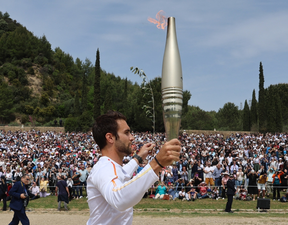 The first torchbearer Greek rower Stefanos Ntouskos carries the touch during the start of the torch relay after the flame lighting ceremony for the Paris 2024 Olympics, Ancient Olympia, Greece, April 16, 2024. — Reuters pic 