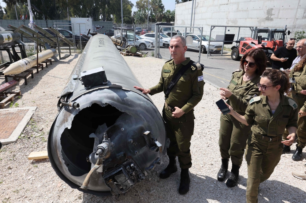 Members of the Israeli military show an Iranian ballistic missile which fell in Israel on the weekend, during a media tour at the Julis military base near the southern Israeli city of Kiryat Malachi on April 16, 2024. — AFP pic