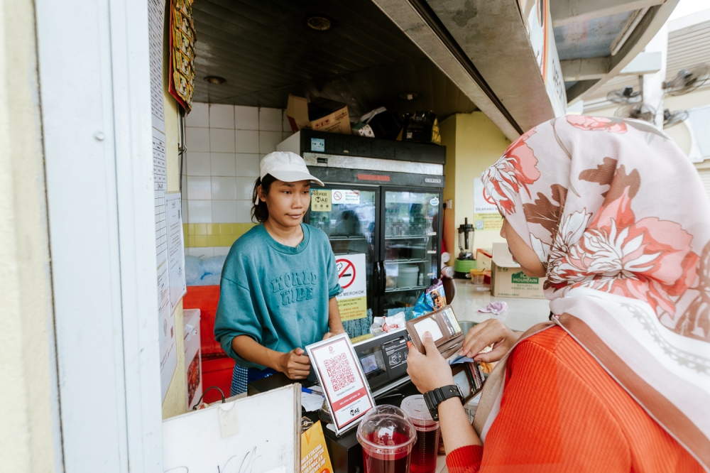 A woman purchases drinks at a shop in Putrajaya March 7, 2024. — Picture by Raymond Manuel