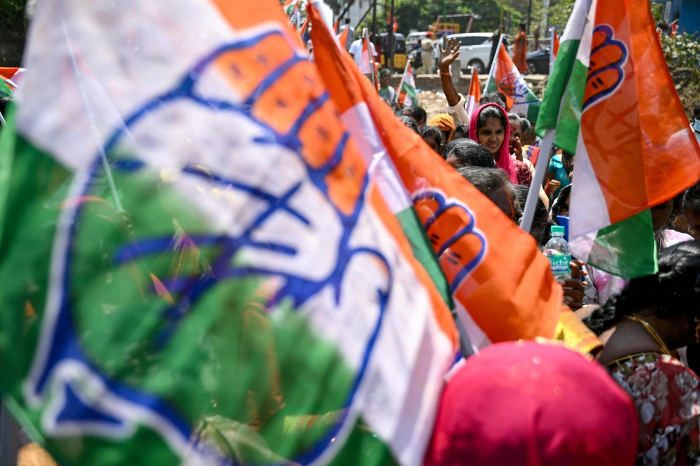 Supporters of India's opposition party, Indian National Congress (INC) wave the party flag as they await the arrival of their party President Mallikarjun Kharge, prior to his public meeting during the election campaign of party candidate V. Vaithilingam in Puducherry on April 15, 2024, ahead of the country's national elections. — AFP pic