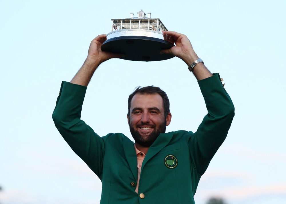 Scottie Scheffler of the US celebrates with his green jacket and the trophy after winning The Masters at Augusta National Golf Club in Augusta April 14, 2024. ― Reuters pic