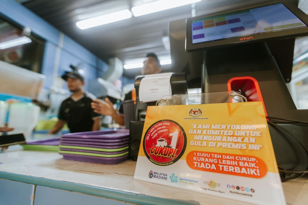 A poster showing the ‘Kurang Manis’ campaign is displayed at a stall in Putrajaya March 7, 2024. — Picture by Raymond Manuel 